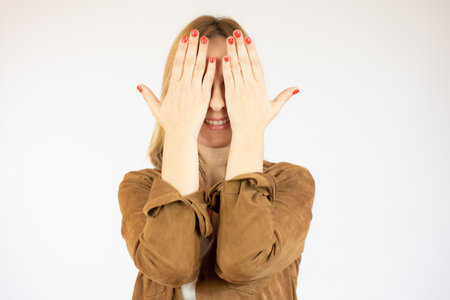 Woman covering her eyes over white background.の写真素材