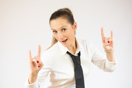 Beautiful business woman over isolated background shouting with crazy expression doing rock symbol with hands up. Music star. Heavy concept.の写真素材