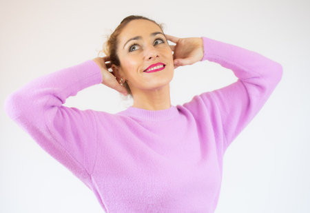 Beautiful woman wearing casual sweater over isolated background confuse and wonder about question. Uncertain with doubt, thinking with hand on head. Pensive happy concept.の写真素材