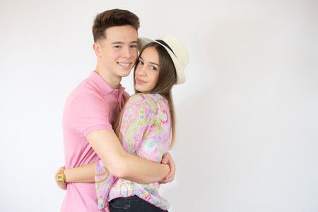 Smiling young couple hugging each other over white background.の写真素材