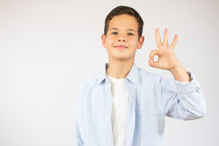 Handsome toddler child with brown eyes raising finger, is the number threeの写真素材