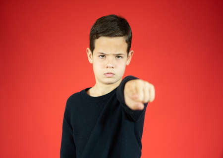 Portrait boy 10 years old, dressed in casual clothes, smiling and points at you with his index finger. I choose you. Human emotions, facial expression conceptの写真素材