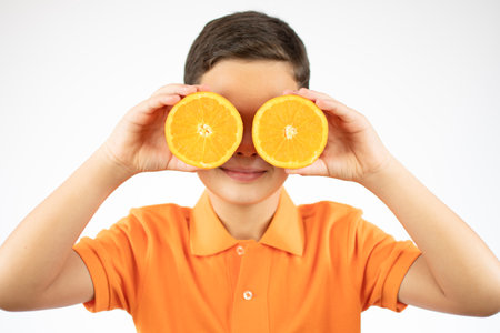 Funny boy with fruits on eyes, isolated on whiteの写真素材