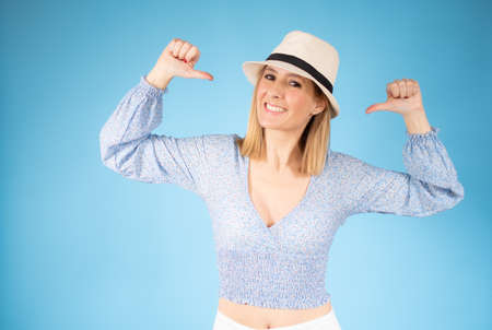 Smiling pretty young woman showing thumbs up isolated over blue background