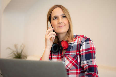 Portrait of young caucasian woman talking with mobile sitting outdoors