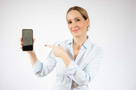 Young business woman showing smart phone over white background.