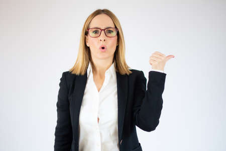 Amazed business woman showing thumb up over white background.の写真素材