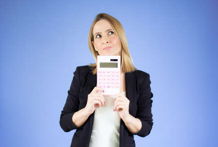 Young business woman hold digital calculator over purple background.の写真素材