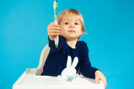 A little boy is learning to brush his teeth using a toothbrush. Concept of child hygiene and...