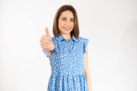 Smiling pretty young woman showing thumb up isolated over white background