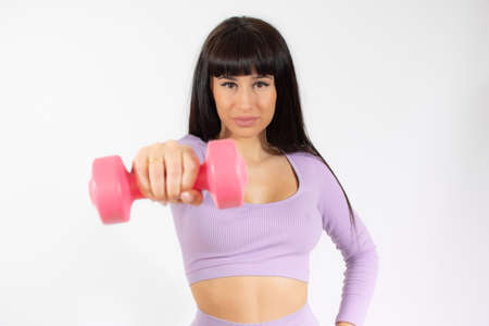 Photo of a healthy training young woman with dumbbell. Healthy lifestyle concept.