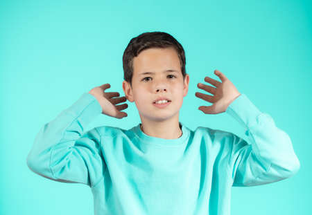Portrait of beautiful emotional little boy on green backgroundの写真素材
