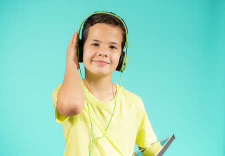 childhood, technology and people concept - smiling boy with headphones over blue background
