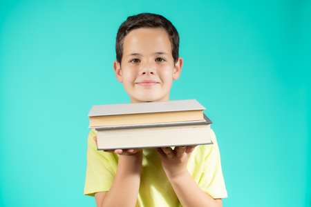 Boy with books for an education portrait - isolated over a green backgroundの写真素材