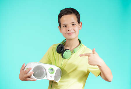 Young boy with headphones and radio over green backgroundの写真素材
