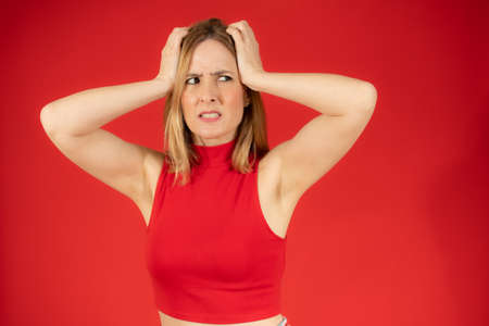 Young caucasian woman with headache and negative face expressionの写真素材