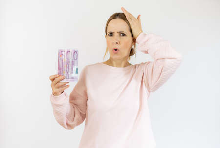 Young excited woman holding piggy bank isolated over white background.の写真素材