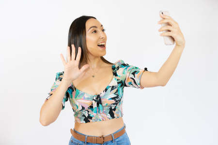 Cheerful young woman talking on mobile phone isolated over white backgroundの写真素材