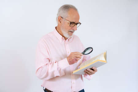 Studio shot of a senior man reading a book on white backgroundの写真素材