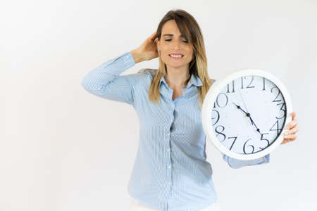 Business woman holding alarm clock with pensive gesture standing over isolated white background.の写真素材