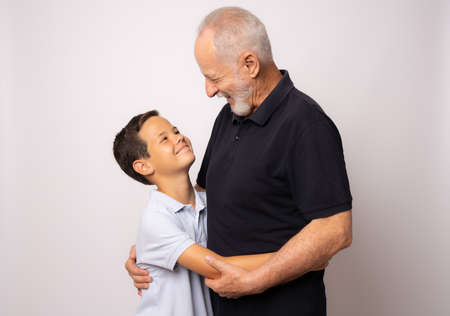 Grandfather and grandson smiling on white background