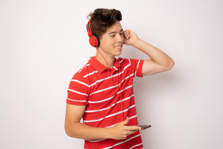 Happy young man with headphones. Listening music over white background.の写真素材
