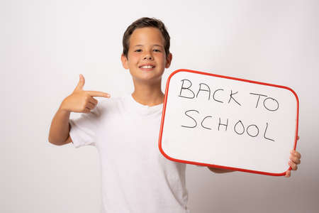 Smiling male student holding signboard isolated over white background. Back to school concept.の写真素材