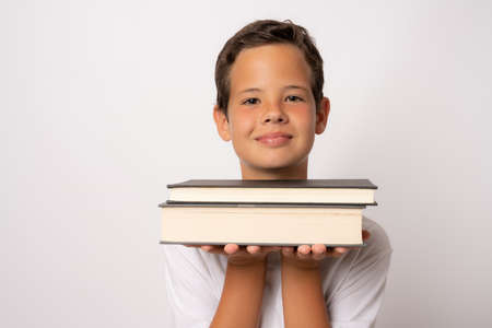Close up portrait smiling schoolboy holding books on white background. Back to school concept.