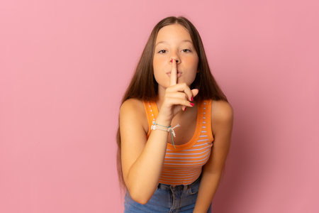 Image of cute pretty girl posing isolated over pink wall background showing silence gesture.の写真素材