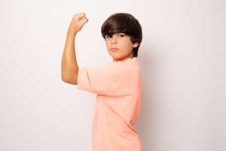 Little but strong. Confident child boy showing his biceps isolated over white background.の写真素材