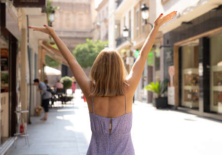 Young woman raising hands up on the city.の写真素材