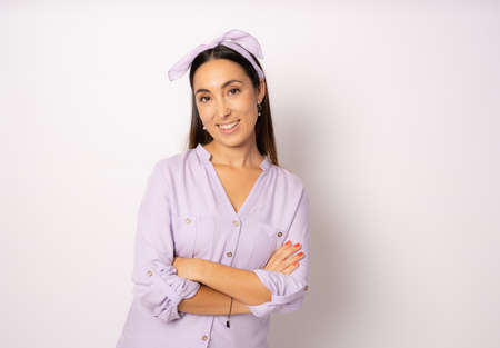 Portrait of a happy woman standing with arms folded isolated on a white backgroundの写真素材