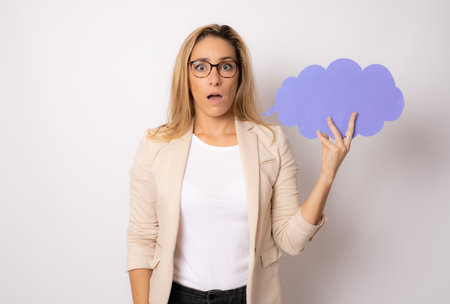 Photo of shocked woman holding paper cloud isolated over white backgroundの写真素材