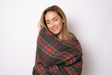 Portrait of a pretty young woman in winter clothing hugging herself. Concept of selfish emotion.の写真素材