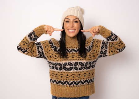 Young woman wearing casual sweater over isolated background smiling confident showing and pointing with fingers teeth and mouth. Health concept.の写真素材
