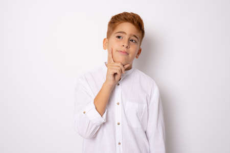 Little redhead boy isolated on white background thinking an ideaの写真素材