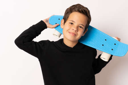 Young cool boy holding skateboard isolated over white background.の写真素材