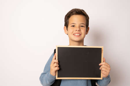 School boy holding a chalk board isolated over white background