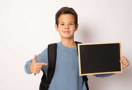 School boy holding a chalk board isolated over white backgroundの写真素材