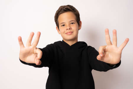 standing young cool boy doing okay sign isolated over white background