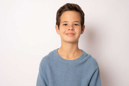 Photo of adorable young happy boy looking at camera isolated over white backgroundの写真素材