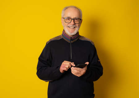 Lifestyle, technology and old people concept: Handsome old gray-haired man dressed in smart casual...