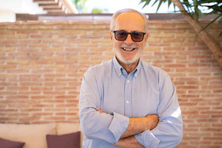 Happy senior man with arms folded outdoors.の写真素材