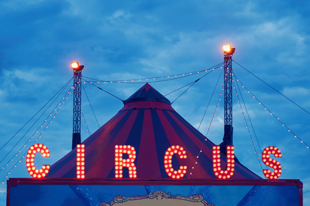 A fragment of the circus design, a dome on the sky background. A circus on wheels. Entertainment for children and adults. Luminous LED signboard, letters of the word circusの写真素材