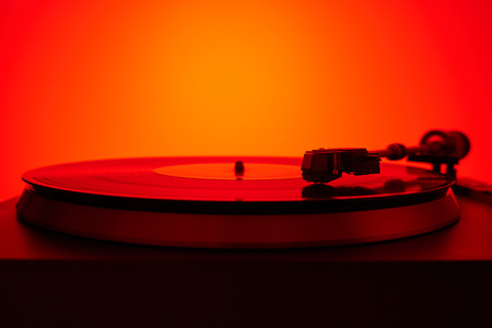 Turntable vinyl record player in the red light. Retro audio equipment for disc jockey.の写真素材
