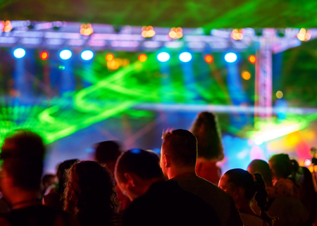 Blurred youth music festival of pop music. Laser show on the stageの写真素材