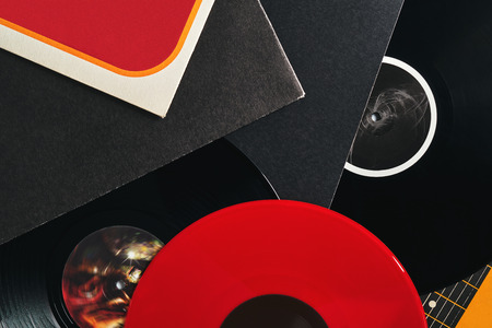 Background of vinyl records DJs for a music player close-up. Red, black, white vinyl records. Retro audio equipment for disc jockey. Sound technology for DJ to mix & play musicの写真素材