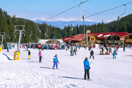 Bansko, Bulgaria - Circa February 2017: Mountain. Skiers climbing on the piste. Ski resort. Ski track. People ski on snow in the winter. Pine forestのeditorial素材