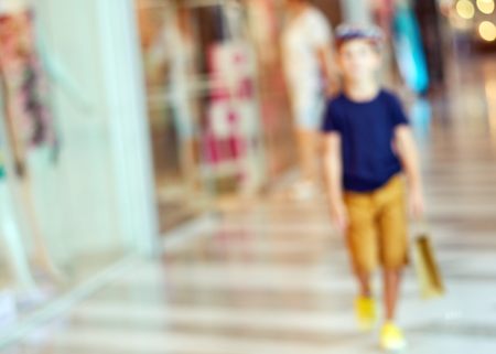 Blurred beautiful lobby at the malls. Big sales on Black Friday for Christmas. Blurred showcases fashion boutique with clothes. Shoppers in the store are reviewing the presented clothesの写真素材