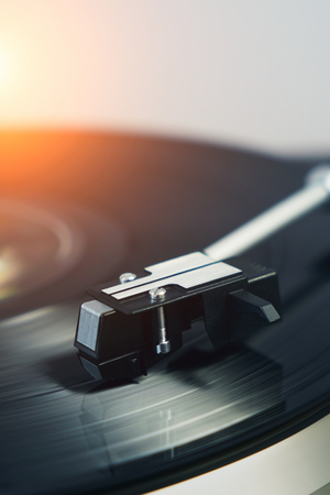 Detail of a turntable vinyl record player. Sound technology for DJ to mix & play music. Black vinyl record. Needle on the plate.  Bright background for the basic designの写真素材